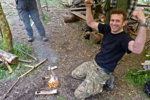 Bushcraft course student celebrates bow-drill success