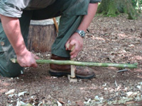 Bow drill friction fire technique demonstrated on elementary bushcraft course