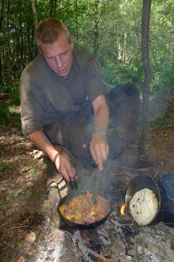 Barry cooking a breakfast of bacon with chanterelles and bannock.
