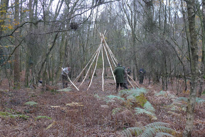Erecting the tipi poles to provide the structure of the tarp tipi on a Frontier Bushcraft course.
