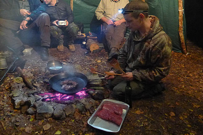 Pan-frying venison over the central fireplace in the tarp tipi