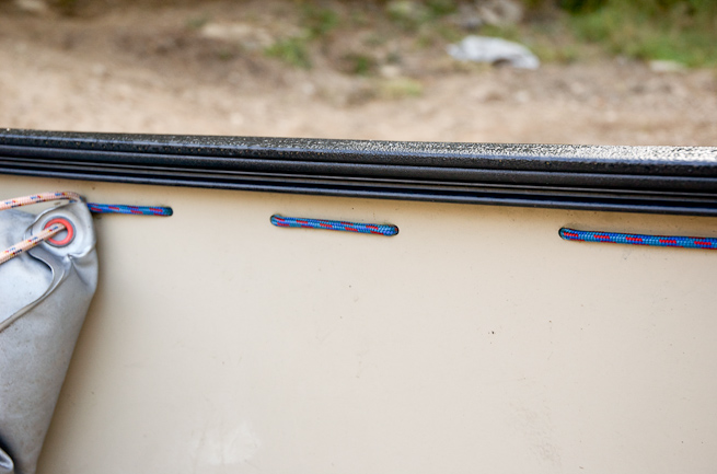 Detail of the cord that is passed through drilled holes down the side of the canoe