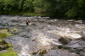 James Bath wading across a river