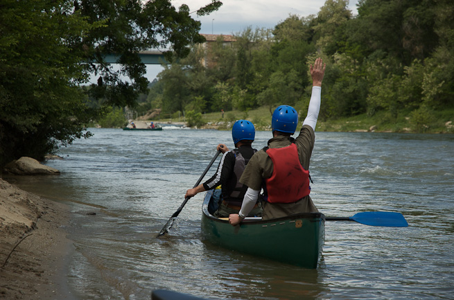 Tandem canoe signalling to another boat further down river.