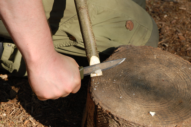 Cutting onto a wooden block wiht a bushcraft knife