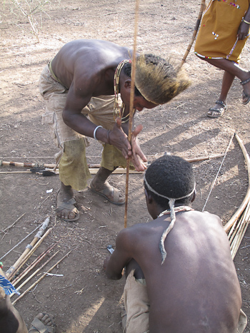 Hadzabe men using hand-drill to light a fire.  