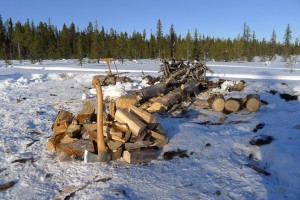 Axe, saw and woodpile