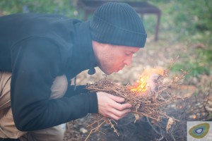 Man blowing bracken to flame