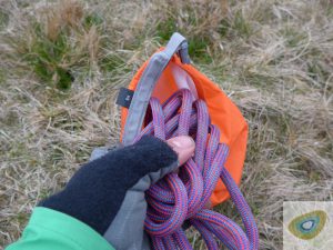 Stuffing coils of rope into the dry bag. Photo: Henry Landon