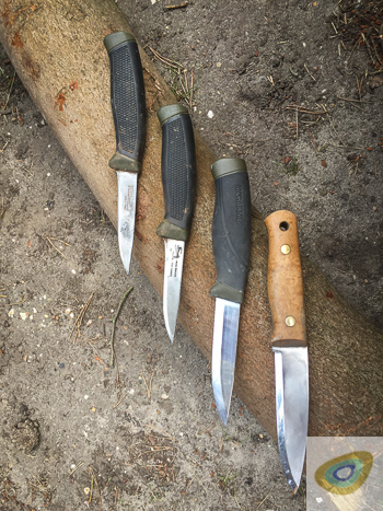 Collection of well used bushcraft knives, including Alan Wood Woodlore