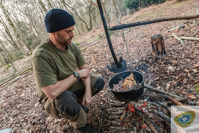 Man next to a campfire and Dutch oven