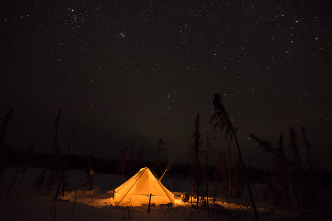 Showing a SnowTrekker canvas tent under a starry sky